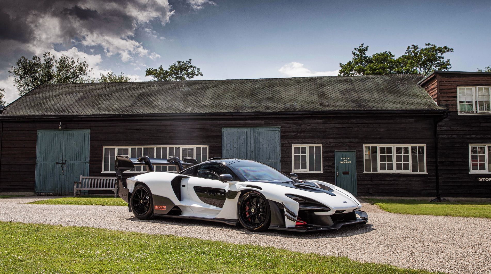 White Prototype McLaren Senna GTR parked outside a Brown shed with green doors